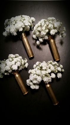 four brass vases filled with white flowers