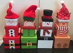 a group of wooden blocks with santa hats and gifts on them sitting next to each other