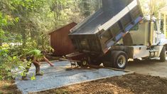 a man is dumping gravel into a dump truck