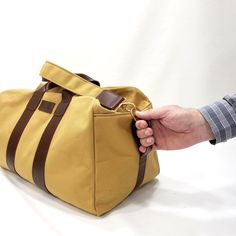 "This Travel Bag is made from 18 oz harvest tan canvas with brown leather trims. SIZE: 20\" wide x 13\" Tall x 11\" depth Features: 2\" adjustable cross bodyt strap (Removable) 2 sides handles Inside zipper pocket 9\"x10\" Metal tooth zipper for long lasting use Stitched with nylon tread for durability. ♡ PROCESSING TIME: Your travel bag will ship within 1-3 business day after purchase. ♡ SHIPPING TIME: 2-5 business days within the US via UPS. ♡ GIFTS: You can ship our products directly to your Airplane Bag, Canvas Travel Bag, Large Travel Bag, Compact Bag, Tan Bag, Mens Travel Bag, Travel Bags For Women, Travel Purse, Round Bag