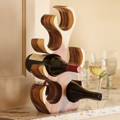 a wooden wine rack holding two bottles of wine on top of a marble countertop