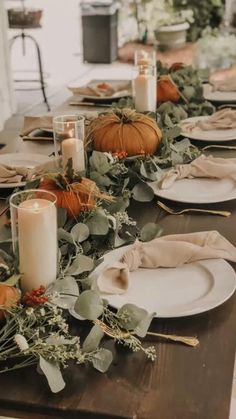 a long table with plates and candles on it