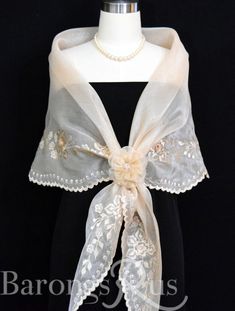 a white shawl with flowers and pearls on it