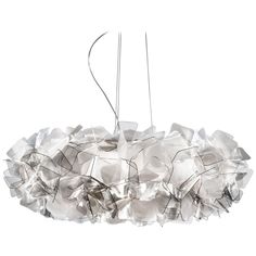 a white light hanging from a ceiling fixture with many pieces of glass on it's sides