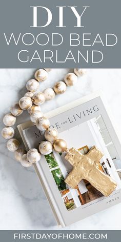 a wooden bead necklace and book on a marble surface with text overlay that reads diy wood bead garland