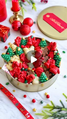 a tin filled with christmas cookies next to other holiday decorations