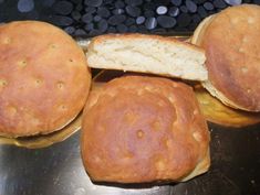 three round breads sitting on top of a metal counter