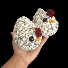 two crocheted chickens are shown in the palm of someone's hand,