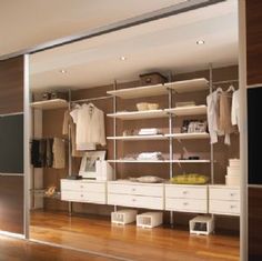 an organized closet with white drawers and shelves