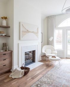 a living room with white walls and wood floors