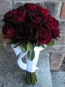 a bouquet of red roses in a white vase