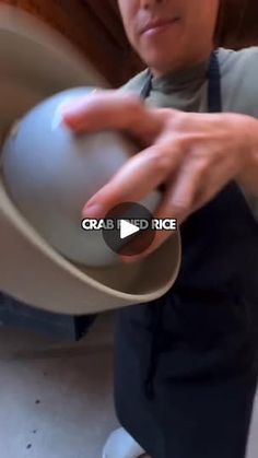 a woman is holding a bowl in her hand and smiling at the camera while she's spinning it