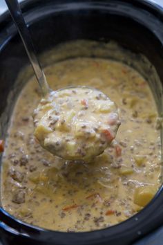 a ladle full of soup being held by a spoon