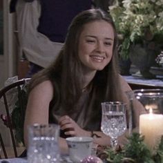 a woman sitting at a table with candles in front of her