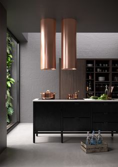 a modern kitchen with black cabinets and copper accents