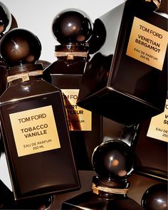 several bottles of tom ford parfum are stacked on top of eachother