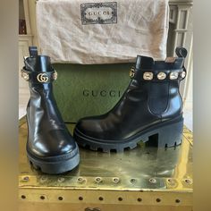 Gucci Chelsea Boot, This Ankle Boot In Shiny Black Leather Is Designed With A Lug Sole And Elastic Inserts On Each Side For A Pull-On Entry. Completed With A Detachable Ankle Strap Dotted With Sparkling Crystals Encased Within Engraved Trims, Resembling Vintage Jewels. The Emblematic Double G Finishes The Front. Black Leather Detachable Ankle Belt With Crystals And Double G Mid-Heel 2.4" Heel Height With .8" Platform 5.5" Shaft Height Made In Italy Foreign Size: Eu42 Smoke Free And Pet Free Home (Used/Like New) One Crystal Is Half Unattached, Simple Repair (As Shown In Photo) Some Shoe Crease/Bend Top Of Shoe. Some Scuff Marks On Sole. ***Box And Dust Bag Sold Sepa Gucci Chelsea Boot, Belt Black, Vintage Jewels, Chelsea Boot, Gucci Shoes, Lug Sole, Mid Heel, Black Belt, Leather Ankle Boots