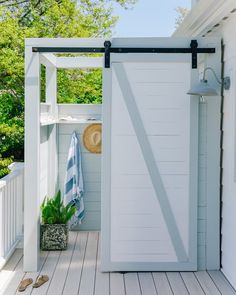 an open door on the side of a white house with a blue towel hanging from it