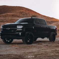 a black truck is parked in the desert