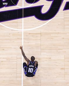 a basketball player on the court with his arms in the air