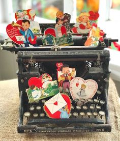 an old typewriter with lots of valentine's day magnets on the keys