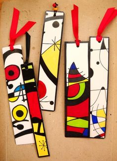 three colorful bookmarks with red ribbons hanging from them