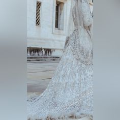 a woman in a wedding dress standing next to a building