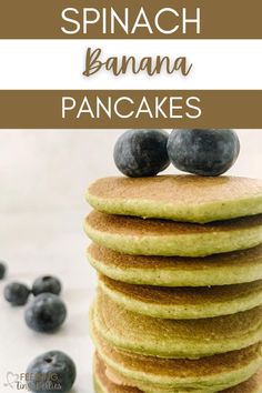 pancakes stacked on top of each other with blueberries in the background and text overlay that reads spinach banana pancakes