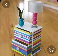 a lamp that is sitting on top of a stack of boxes in the middle of a wooden floor