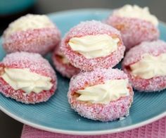 powdered sugar covered donuts on a blue and white plate with pink napkins