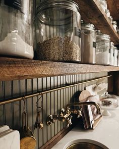 the shelves are filled with jars and other items on top of the kitchen countertop