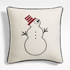 a white pillow with a snowman drawn on it's side and a red hat on its head