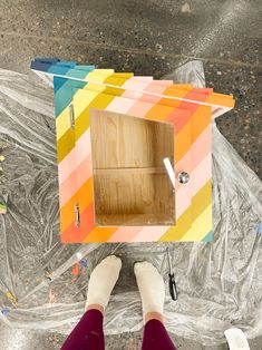 a person standing in front of a colorful box