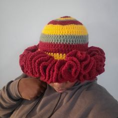 a man wearing a crocheted hat with flowers on it