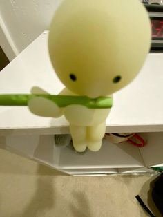 a small plastic figure holding a green object