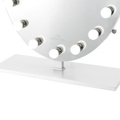 a mirror that is on top of a white stand with holes in the middle and several lights around it