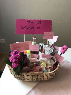 a basket filled with lots of items sitting on top of a table next to a sign that says new job survival kit