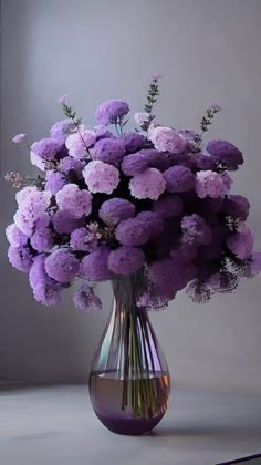 a vase filled with purple flowers on top of a table