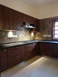 a kitchen with wooden cabinets and tile backsplashes on the counter tops, along with two lights