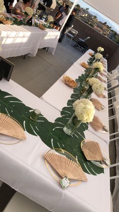 a long table with flowers and plates on it