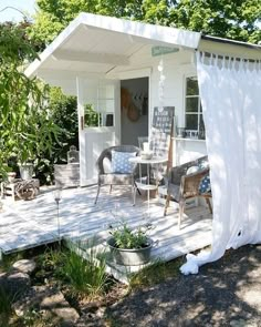 a small white house sitting on top of a wooden deck