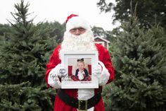 a man dressed as santa claus holding up a photo