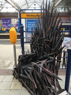 a large iron throne sitting on top of a tiled floor next to a yellow sign