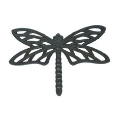 a metal dragonfly sitting on top of a white wall