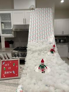 a christmas tree made out of fake snow in a kitchen with a sign saying let it snow