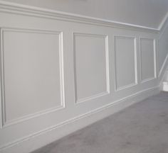 an empty room with white paneled walls and carpeting on the floor is pictured in this image