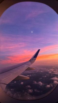 the view from an airplane window at sunset