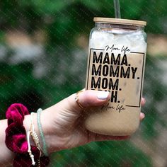 a woman holding up a jar filled with ice cream and coffee in front of her face