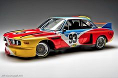 an old model bmw race car painted in different colors and numbers on it's side