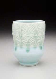 a white and blue vase sitting on top of a table